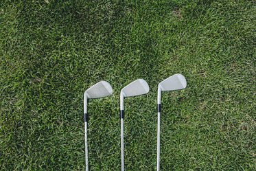 three golf clubs on green