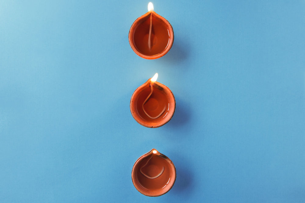 three orange wick diya