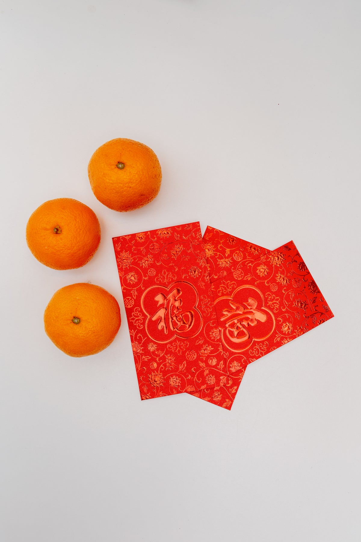three oranges and three fanned out red cards on white