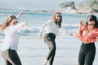 three people have fun on a beach