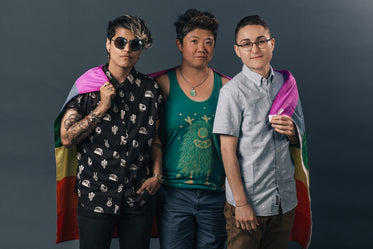 three people holding pride flag