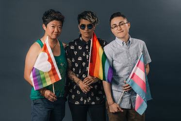 three people holding pride flags