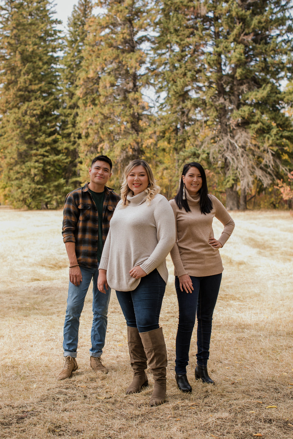 three people in sweaters pose for the camera