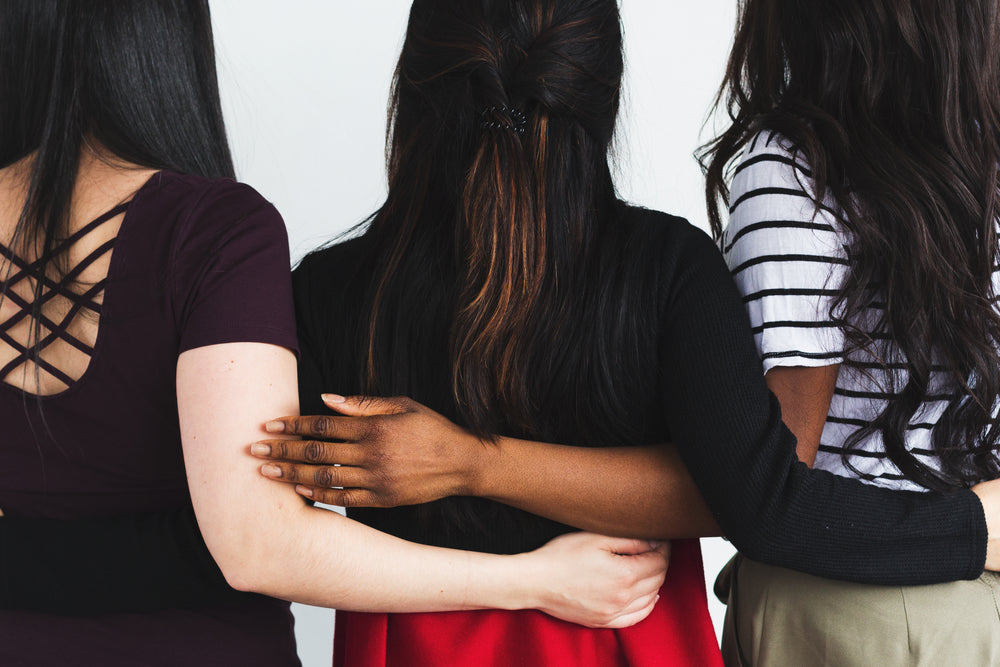 three people interlace arms