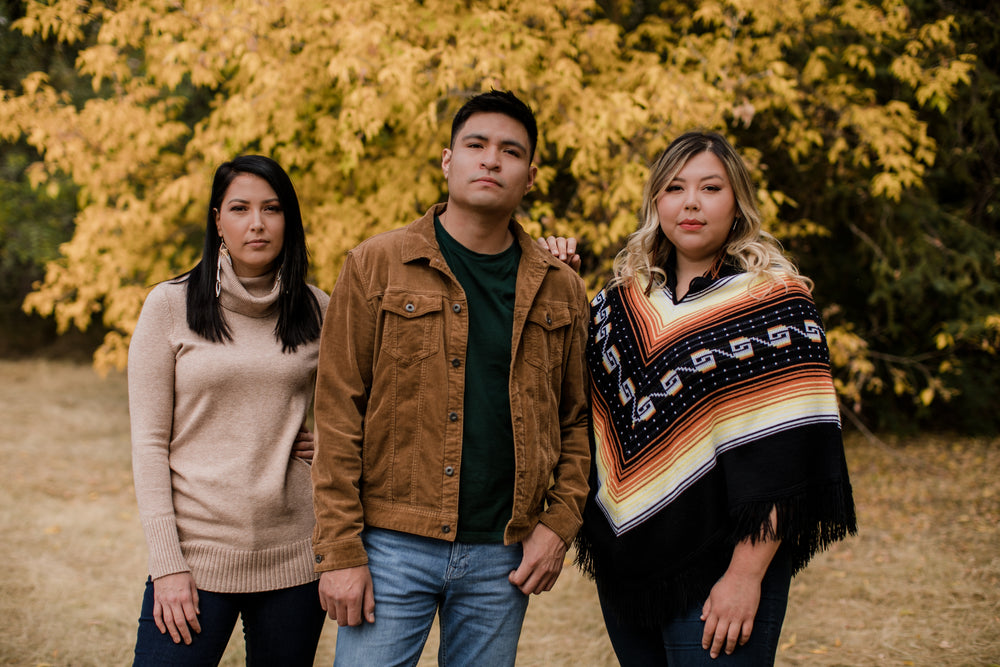 three people look at camera on a fall day