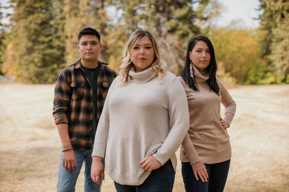 three people looking directly at camera outside on a fall day