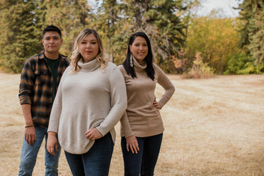 three people outdoors standing to left frame