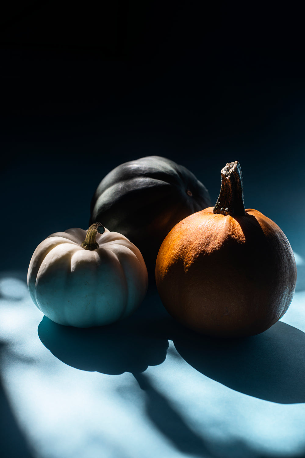 three pumpkins sitting in a beam of light