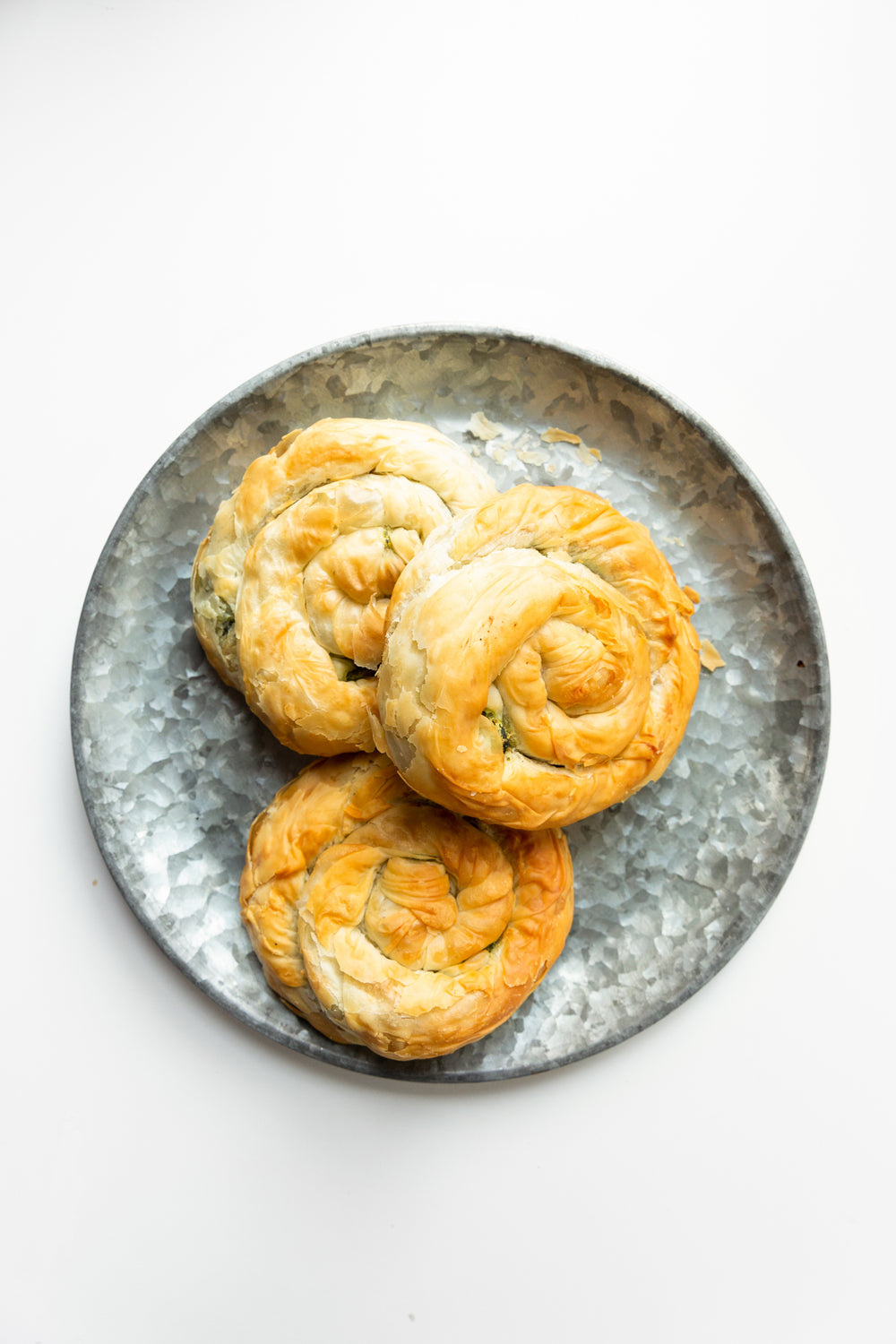 three spanakopita spirals on textured plate