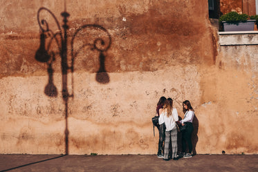 three women by a rustic wall