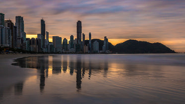 tide rolls into a beach side city at sunset