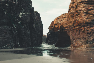 tide rolls into shore between rocks