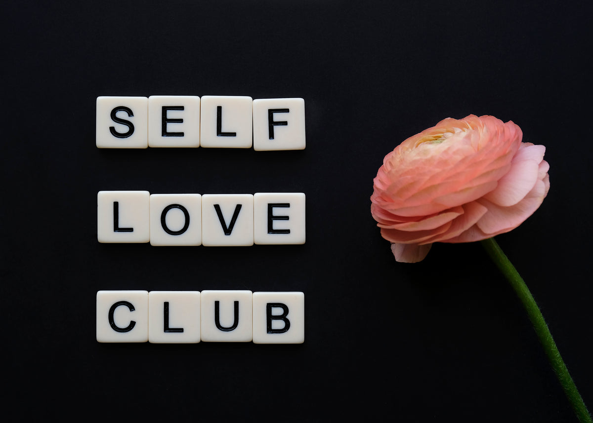 tiles read self love club next to a pink flower