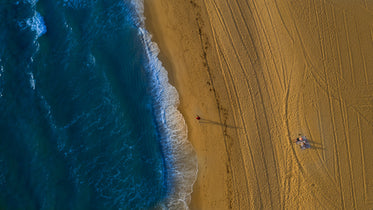 tire tracks across the beach and deep blue ocean