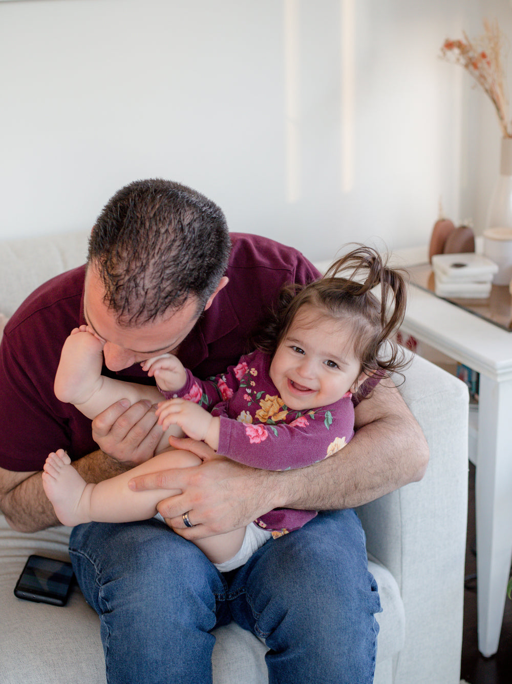 toddler laughing head down and sitting on someones lap