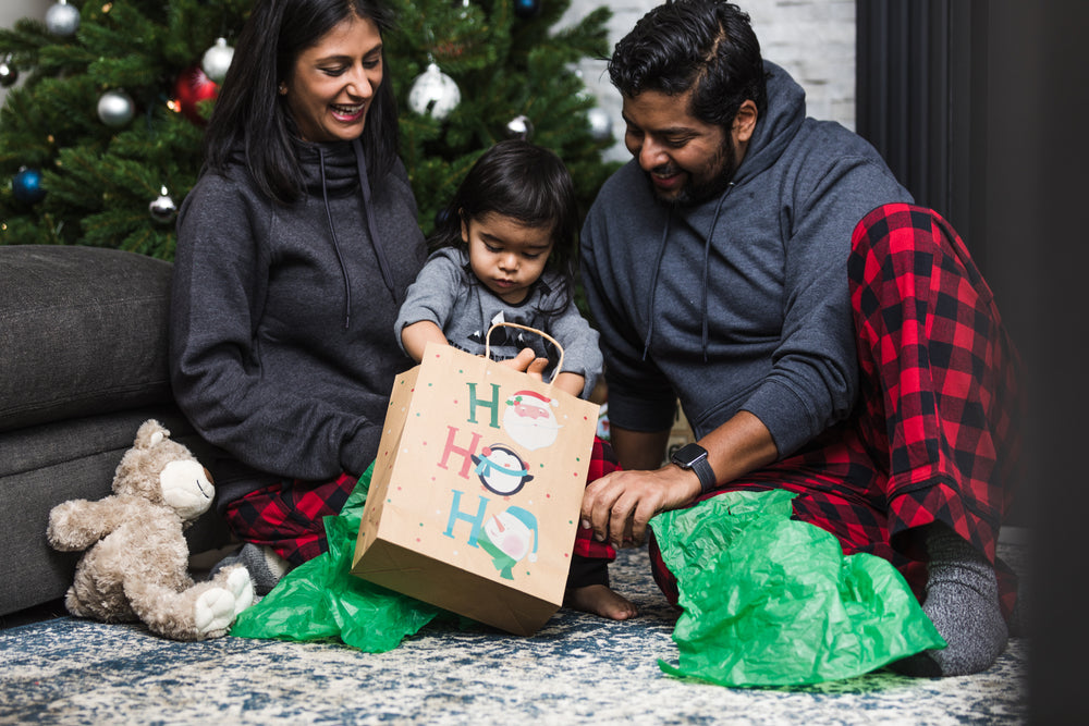 criança pequena abre os presentes de natal