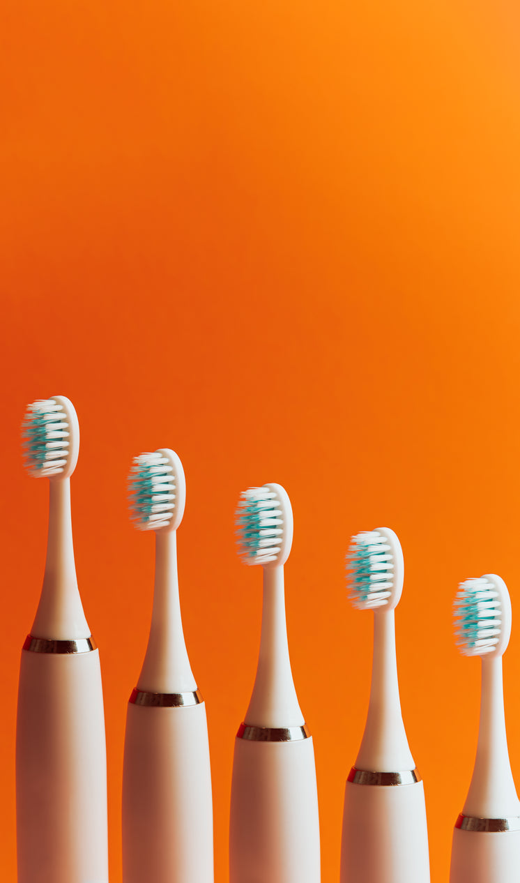 toothbrushes-lined-up-in-a-row-against-o