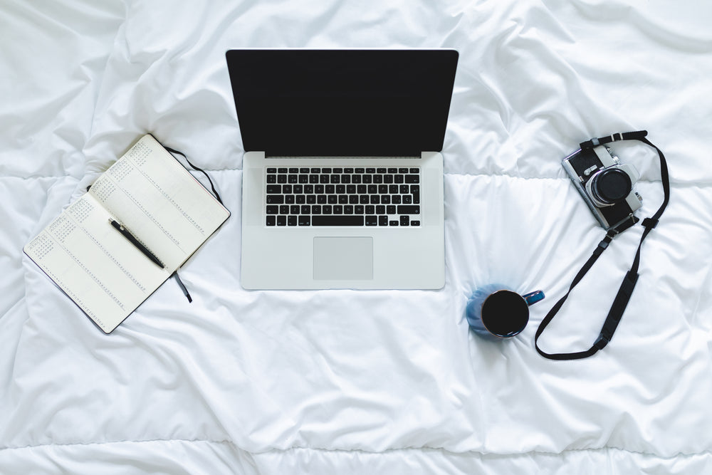 top down view working from home on a bed