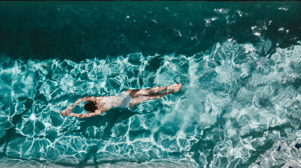 top view of a woman gliding through a pool underwater