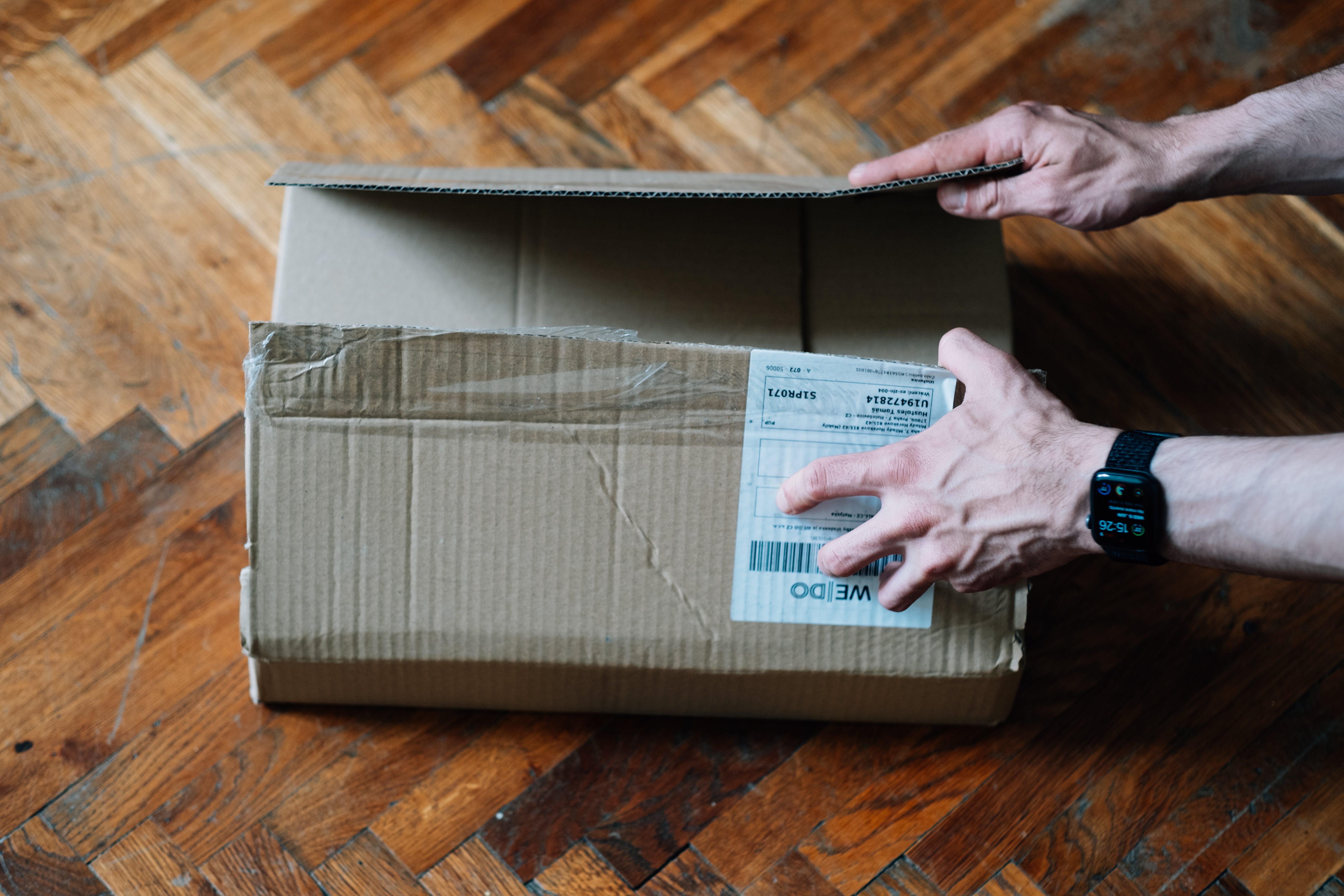 Top View Of Hands Ready To Open A Cardboard Box