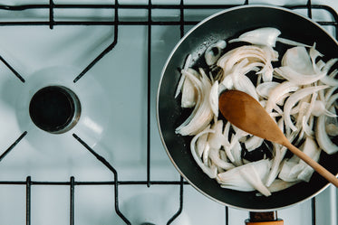 top view of white onions being saved in a frying pan