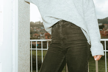 torso of person in black jeans and a grey soft sweater