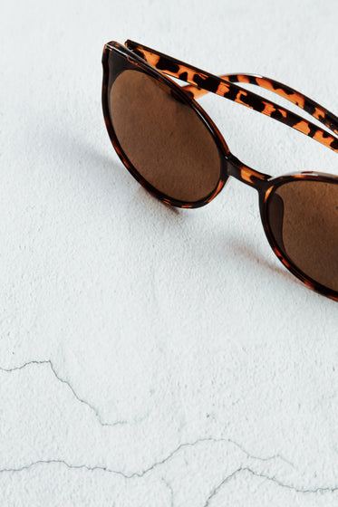 tortoise shell sunglass frames on a white surface