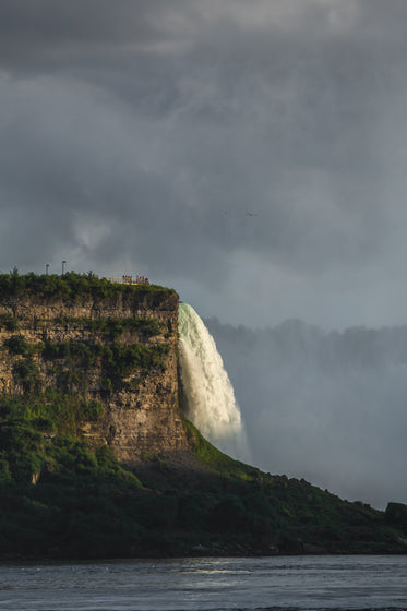 tourists gather on cliff viewpoint overlooking niagara falls