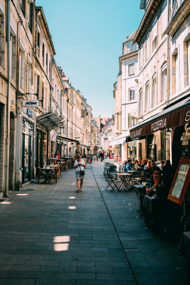 tourists sit outside a pizzeria on a european street