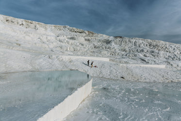 tourists traverse reflective thermal pools