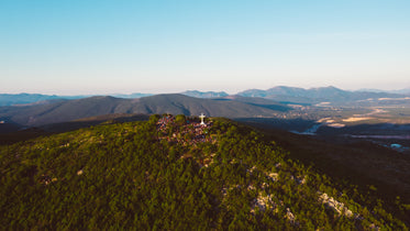 tourists visit a large cross stood at a mountain top