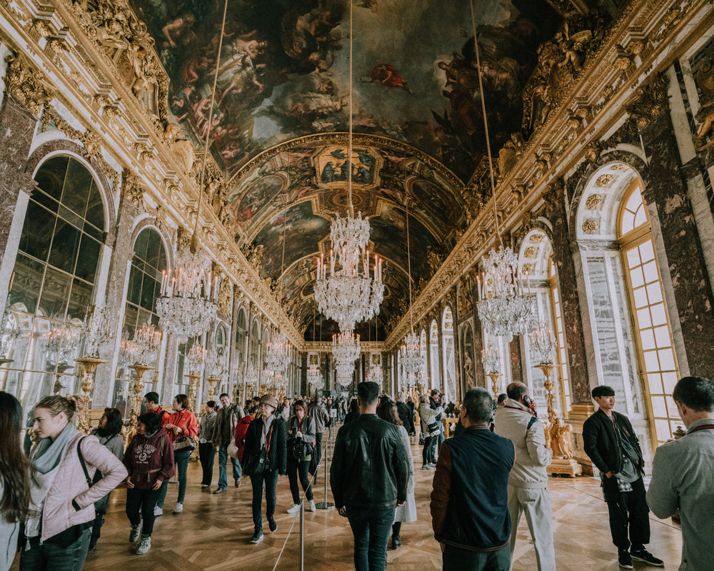 tourists wander through versailles hallways