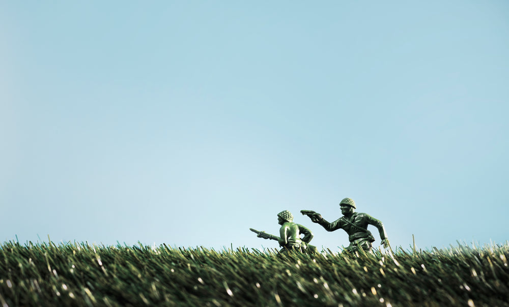 toy soldiers run through tall grass