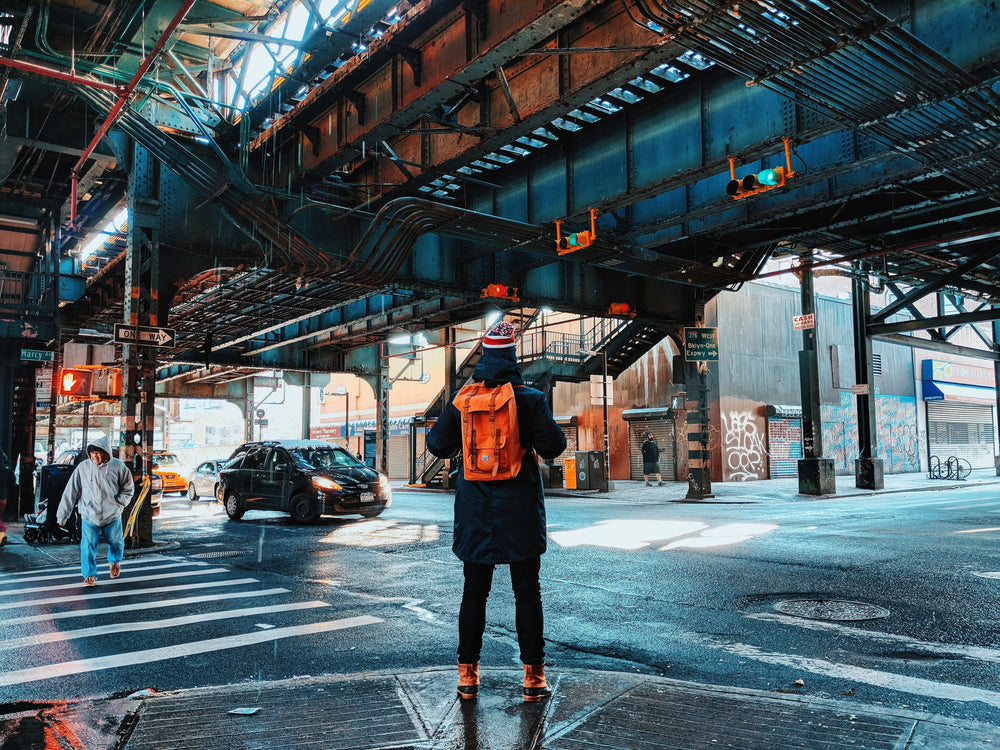 traveller in nyc with backpack under bridge