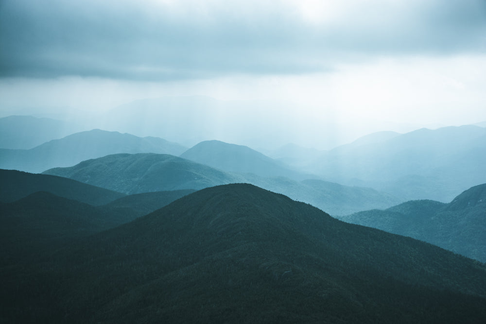 tree-covered hills against a grey sky