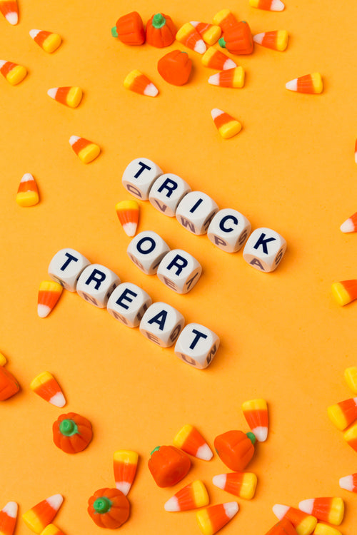 trick or treat on an orange background with candy corn