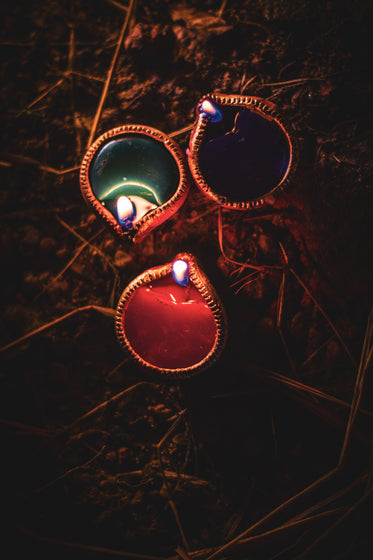 trio of clay candle pots laying on ground