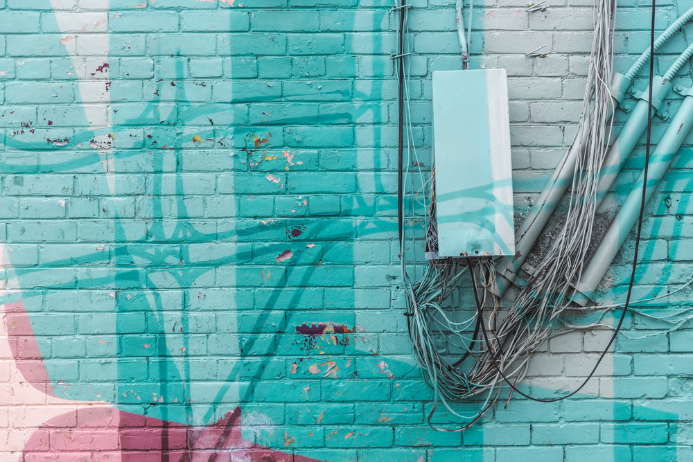 turquoise brick wall with wires