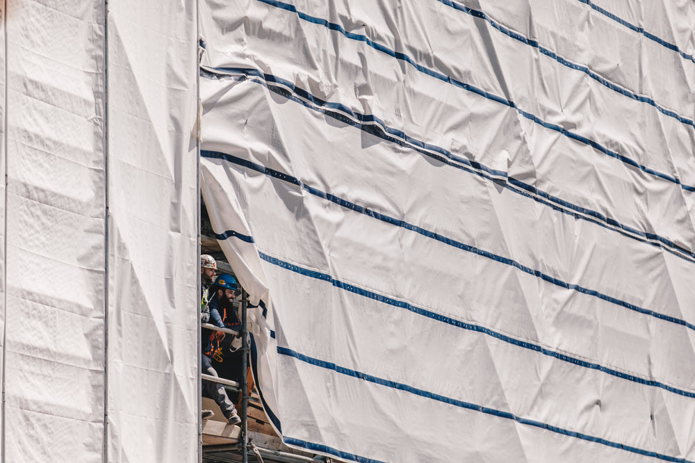 two builders smile from scaffolding