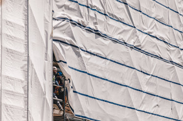 two builders smile from scaffolding