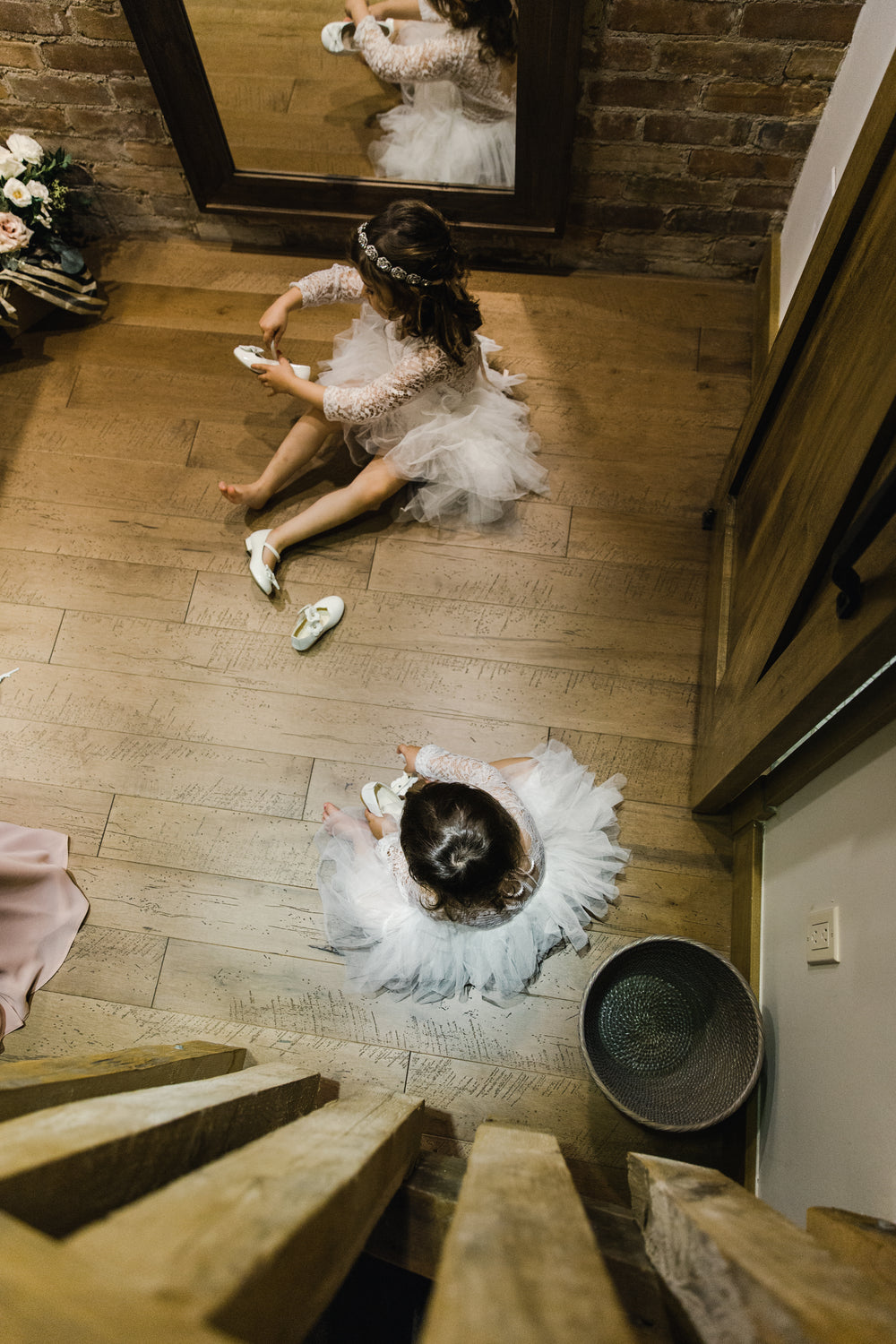 two children in wedding attire putting on shoes