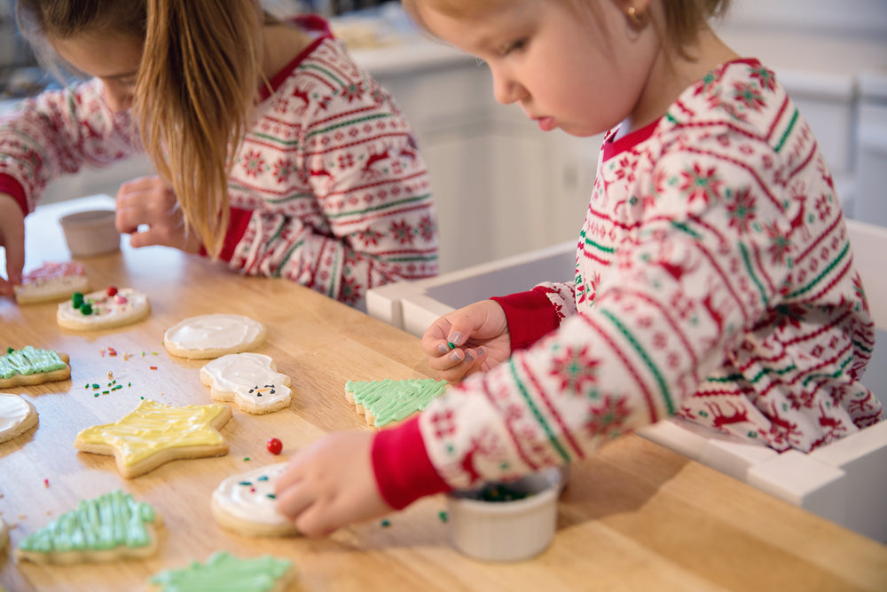 two girls decorating christmas cookies