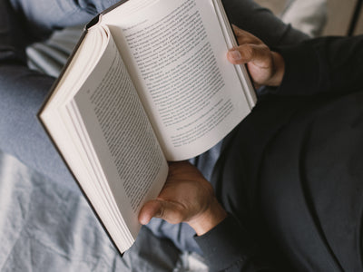 Two Hands Hold A Book Open To Read