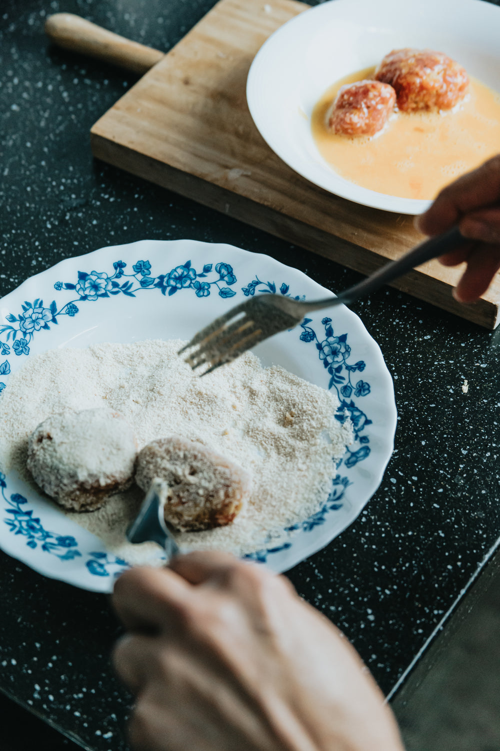 two hands holding two forks