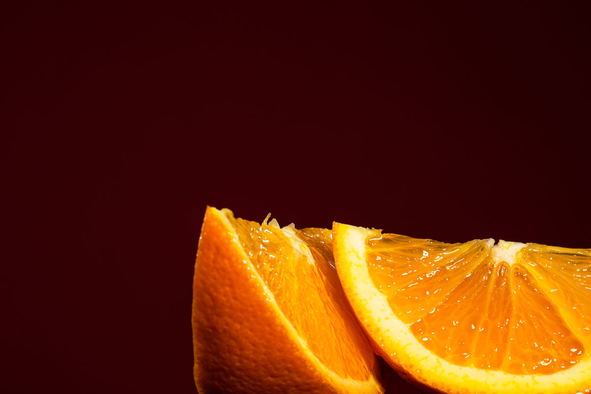 two juicy orange slices against red background