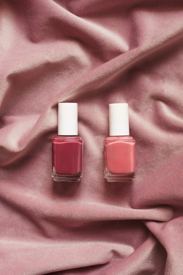 two nail polishes on pink