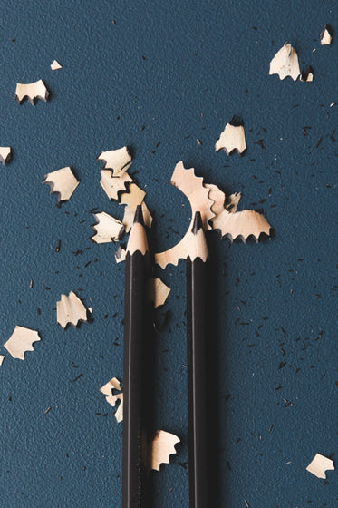 two newly shaved pencils lie in their shavings