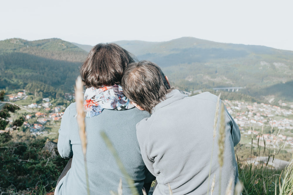 two people away from camera enjoying a distant view