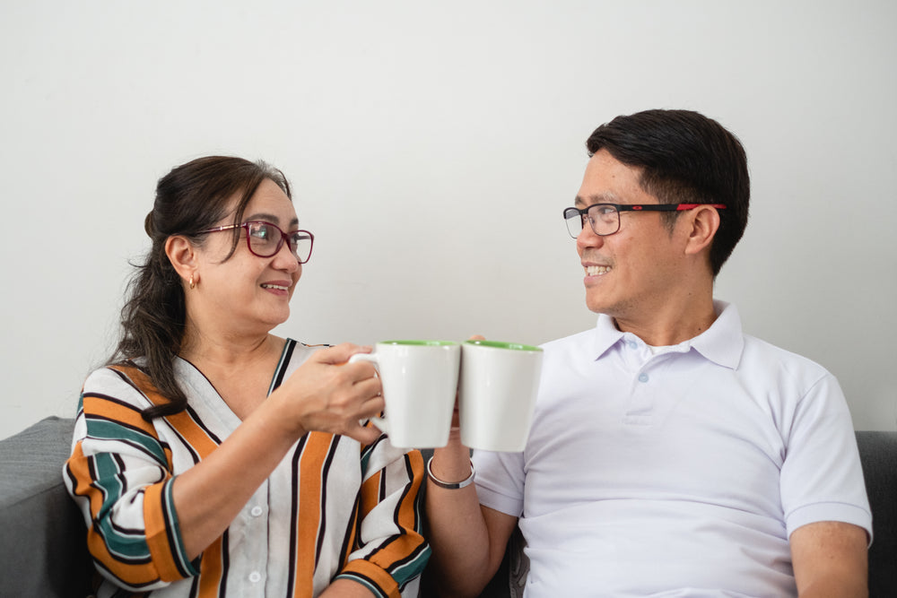 two people cheers with coffee cups