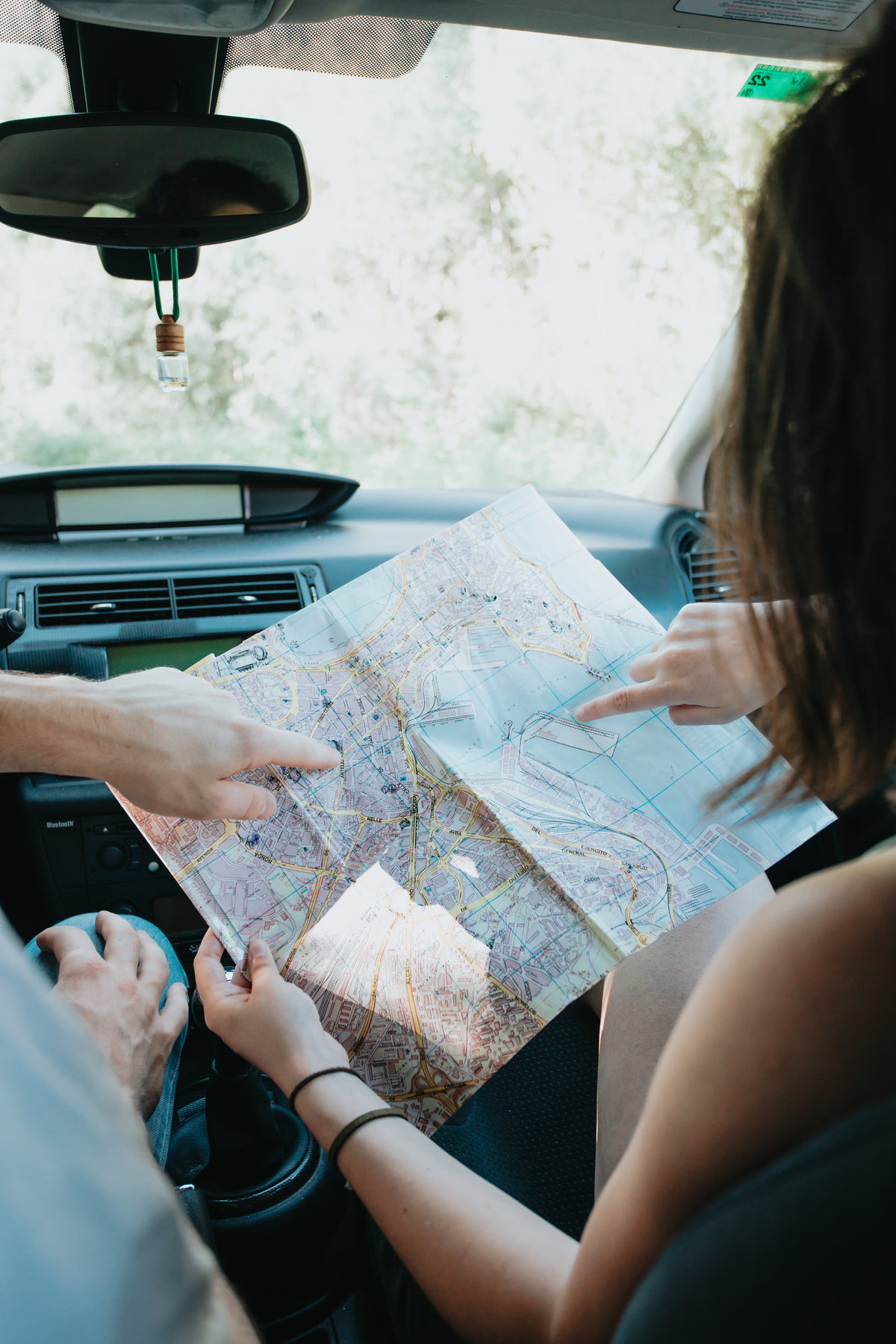 two people hands hold a map in a car